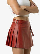 Red pleated skirt worn by a person on a white background