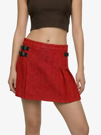 Red skirt with black buckles worn by a person on a white background