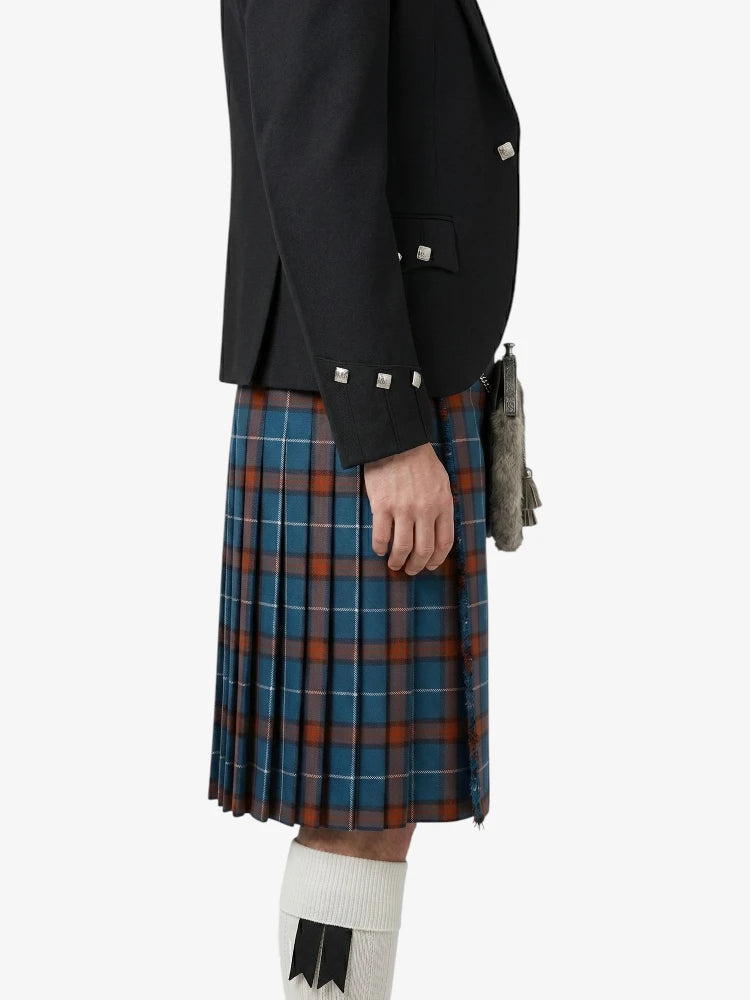 Person wearing a black jacket and plaid kilt on a white background