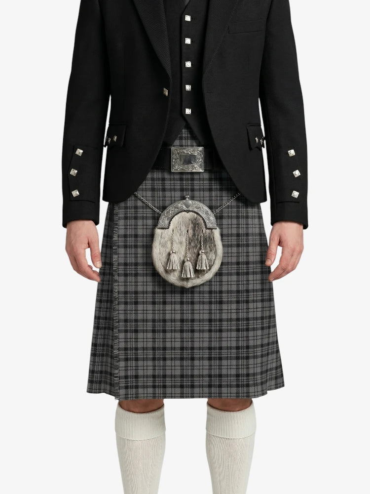 Person wearing a black jacket and gray plaid kilt with a tartan emblem on a white background