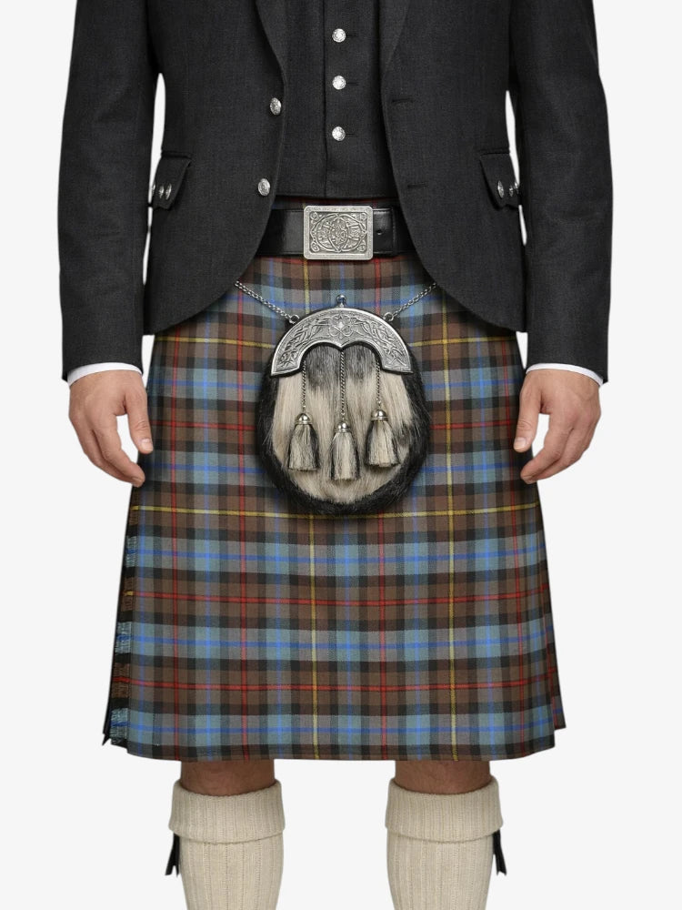 Person wearing a traditional Scottish kilt with a tartan pattern on a white background