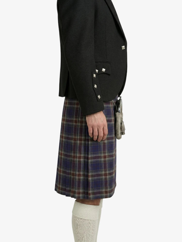 Person wearing a black blazer and plaid kilt on a white background