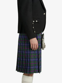 Person wearing a black blazer and plaid kilt on a white background
