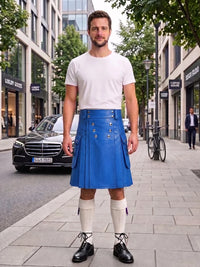 A man stands on a city sidewalk wearing a bright blue leather kilt with gold-tone buttons, a white t-shirt, white knee-high socks, and black leather shoes. Buildings, trees, a parked black car, and a bicycle are visible in the background.