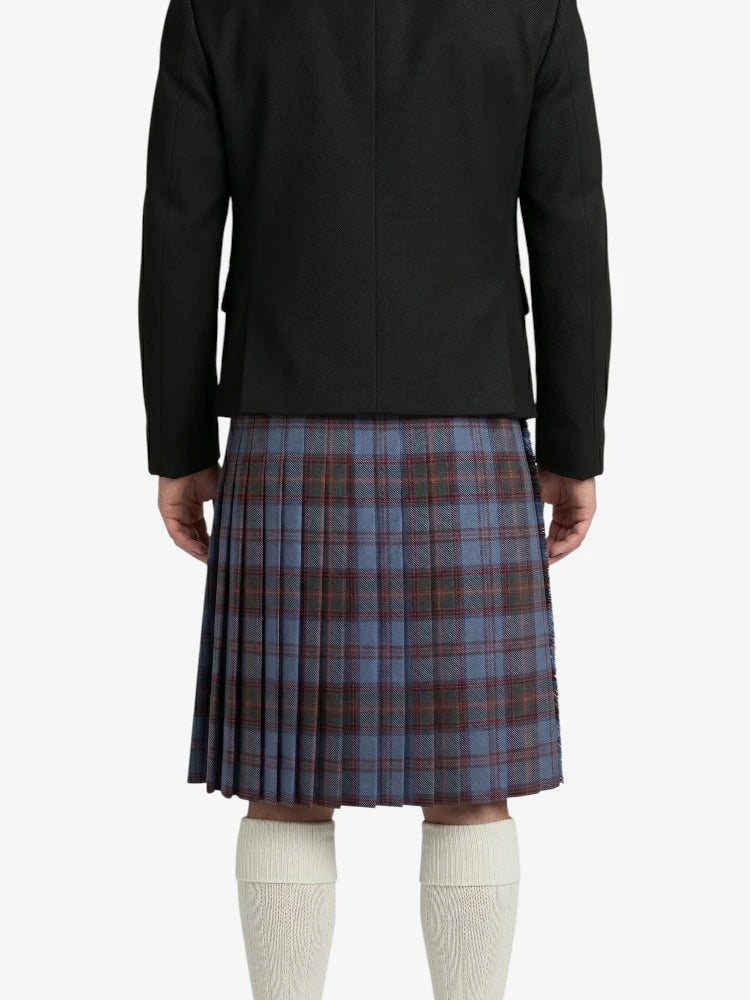 Person wearing a black jacket and plaid kilt on a white background