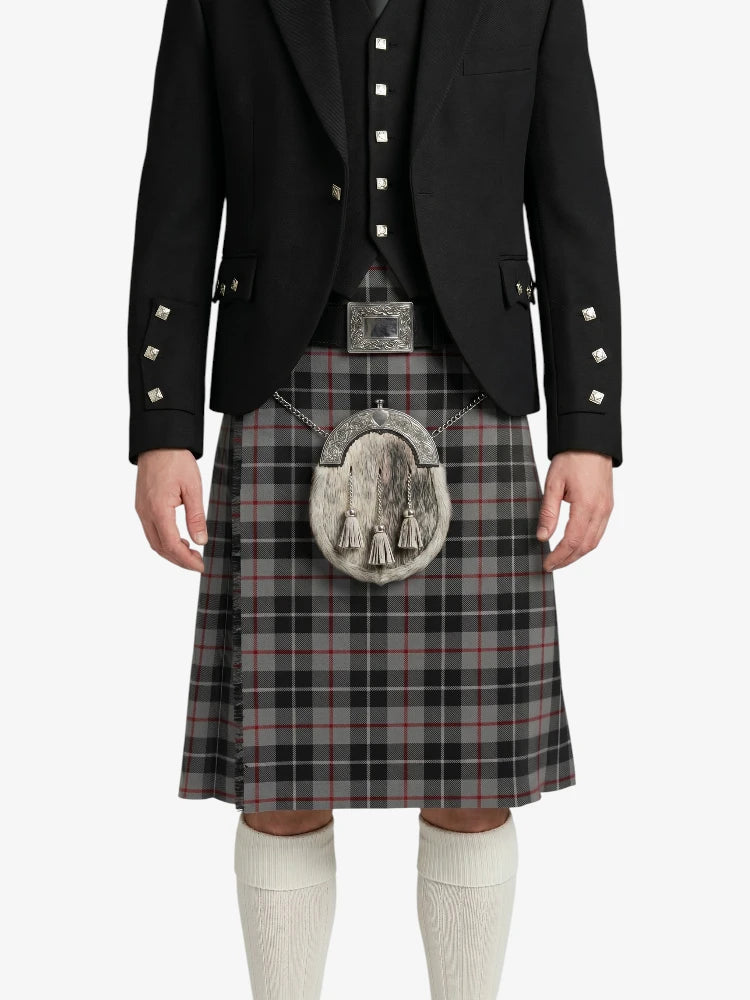 Person wearing a black jacket, vest, and plaid kilt with a silver sporran on a white background