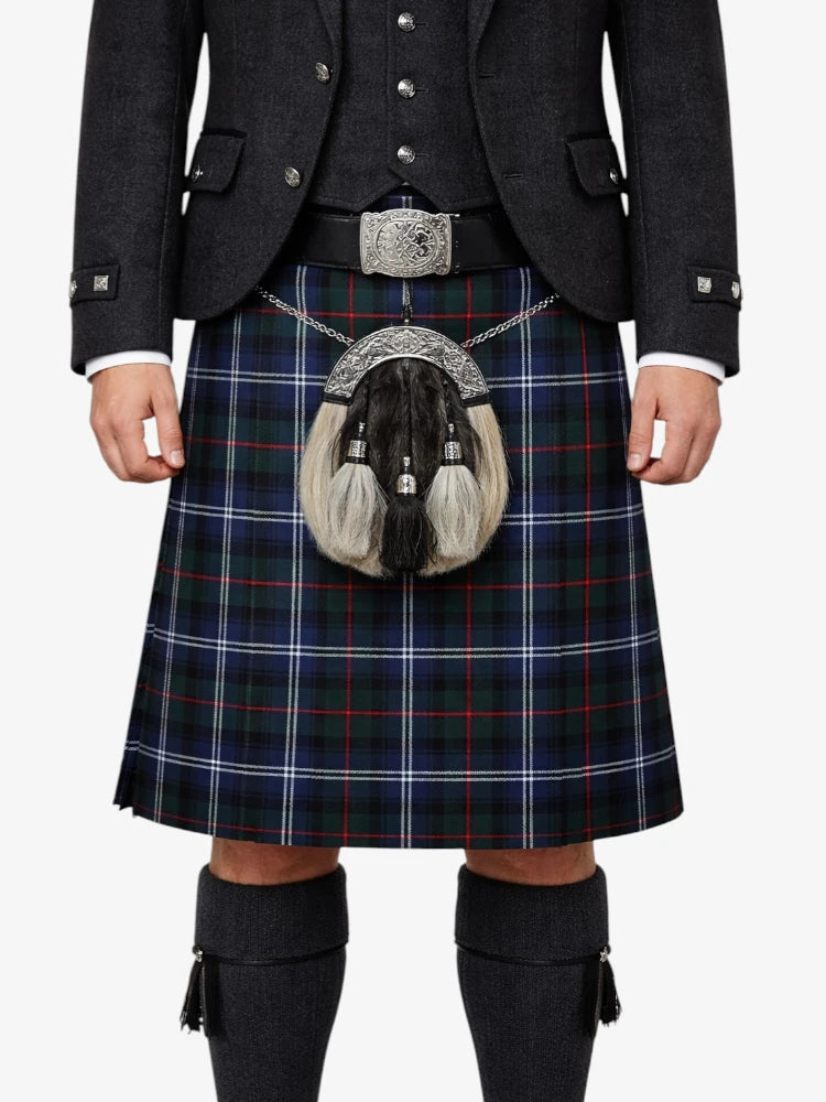 Person wearing a traditional Scottish kilt with a tartan pattern on a white background