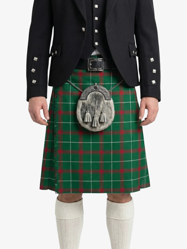 Person wearing a traditional Scottish kilt with a green plaid pattern on a white background