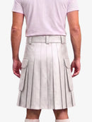 A person shown from the back wearing a light beige pleated kilt-style skirt with a matching belt and side flap pockets, paired with a pale pink T-shirt and light socks, against a plain light background.