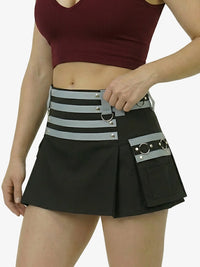 Person wearing a black skirt with a gray belt featuring multiple pockets and straps on a white background