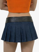 Person wearing a navy pleated skirt with a black waistband on a white background
