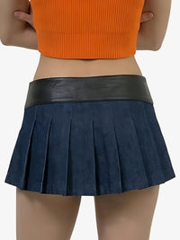 Person wearing a navy pleated skirt with a black waistband on a white background