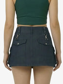 Person wearing a dark green crop top and black skirt on a white background