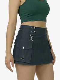 Person wearing a black utility skirt with pockets and silver hardware on a plain background