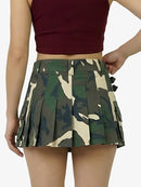 Person wearing a maroon crop top and camouflage pleated skirt on a white background