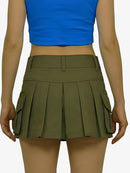 Person wearing a blue top and green pleated skirt on a white background