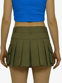 Person wearing a blue top and green pleated skirt on a white background