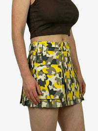 Person wearing a yellow and green camouflage skirt on a white background