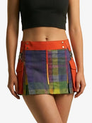 Multicolored plaid skirt with orange accents worn by a person on a white background