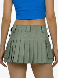 Person wearing a green pleated skirt and blue top on a white background