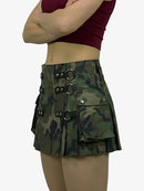 Camouflage skirt with metal buckles worn by a person on a white background