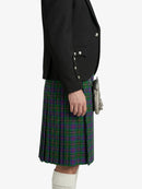 Person wearing a black blazer and green plaid kilt on a white background